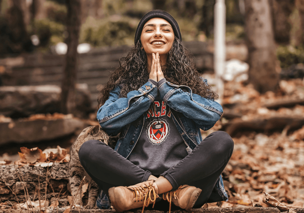 Woman smiling in woods doing meditation