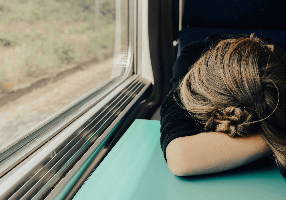 Young woman resting head on train table