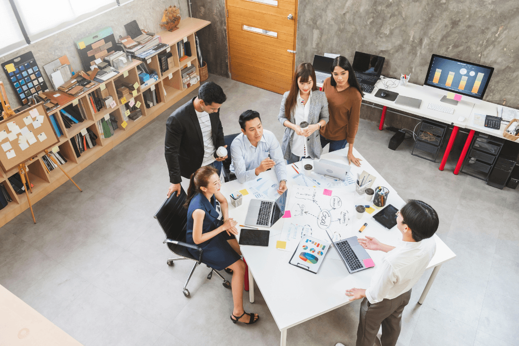Employees discussing work around a table