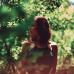 Young woman standing in forest in summer