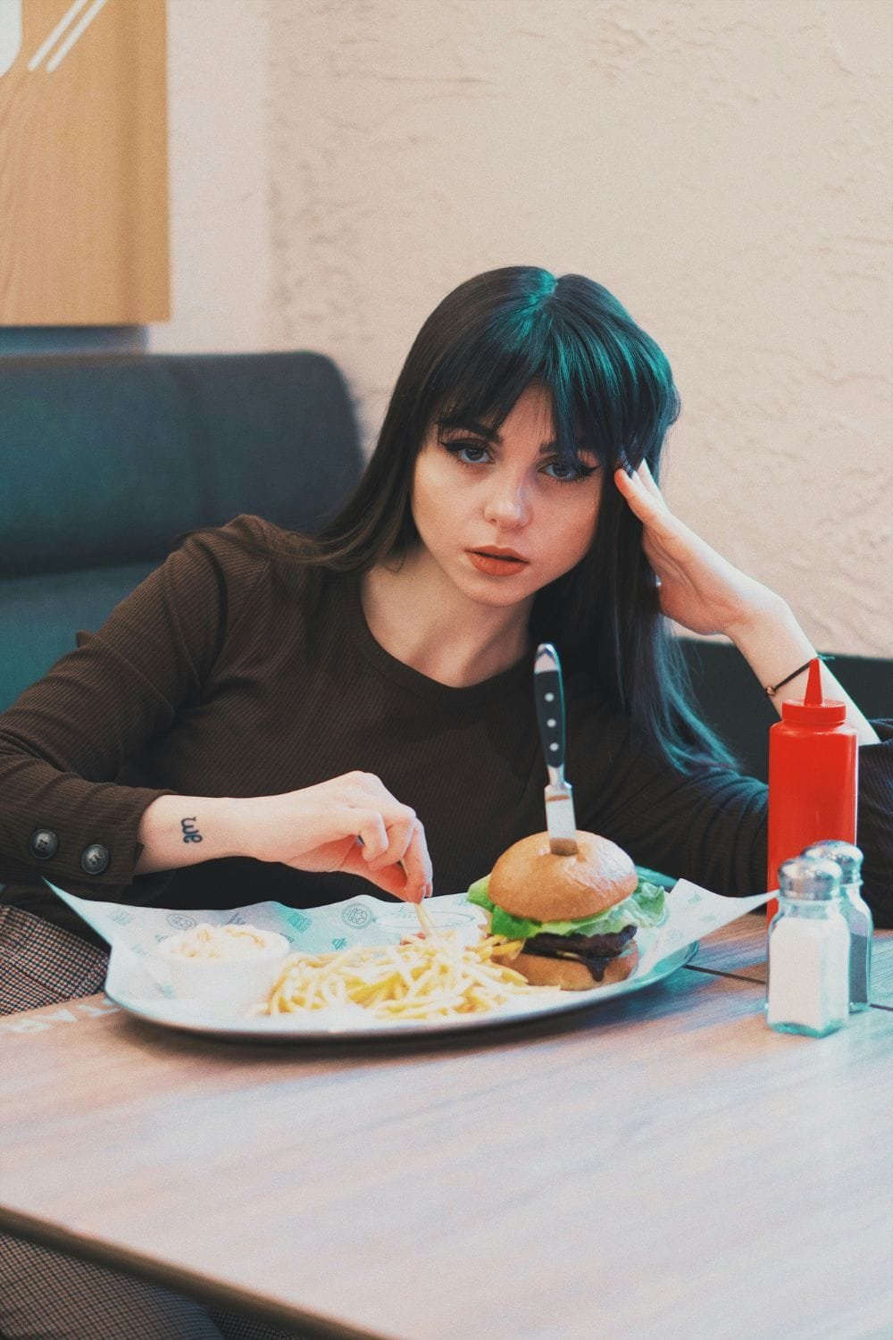 Thin girl with plate of food looking at the camera