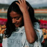 Woman in field of tulips looking thoughtful