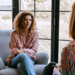 Woman sitting in a chair talking to a therapist