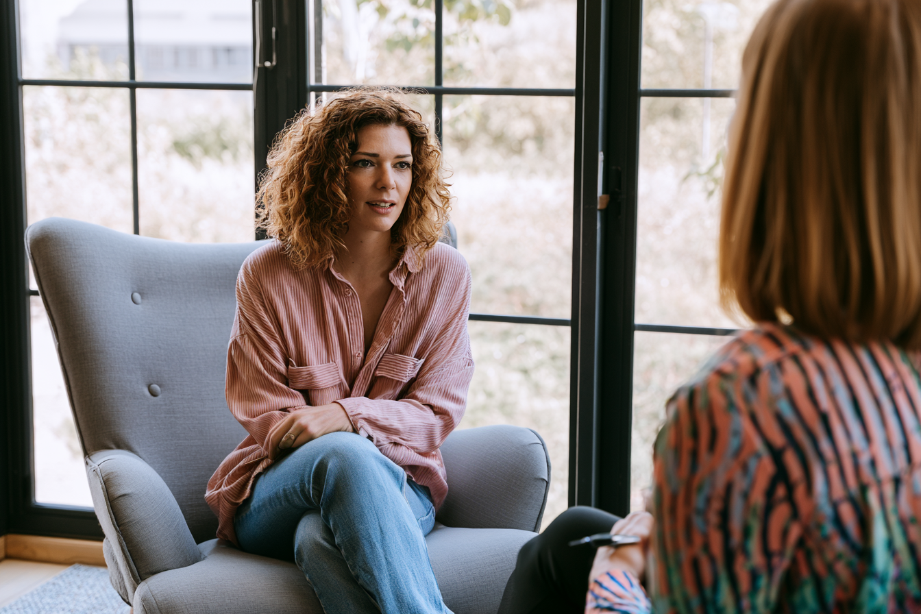 Woman sitting in a chair talking to a therapist