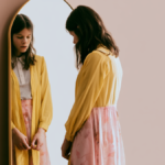 Young woman standing in front of mirror