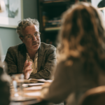 Male psychatrist talking to teenage girl in consultation